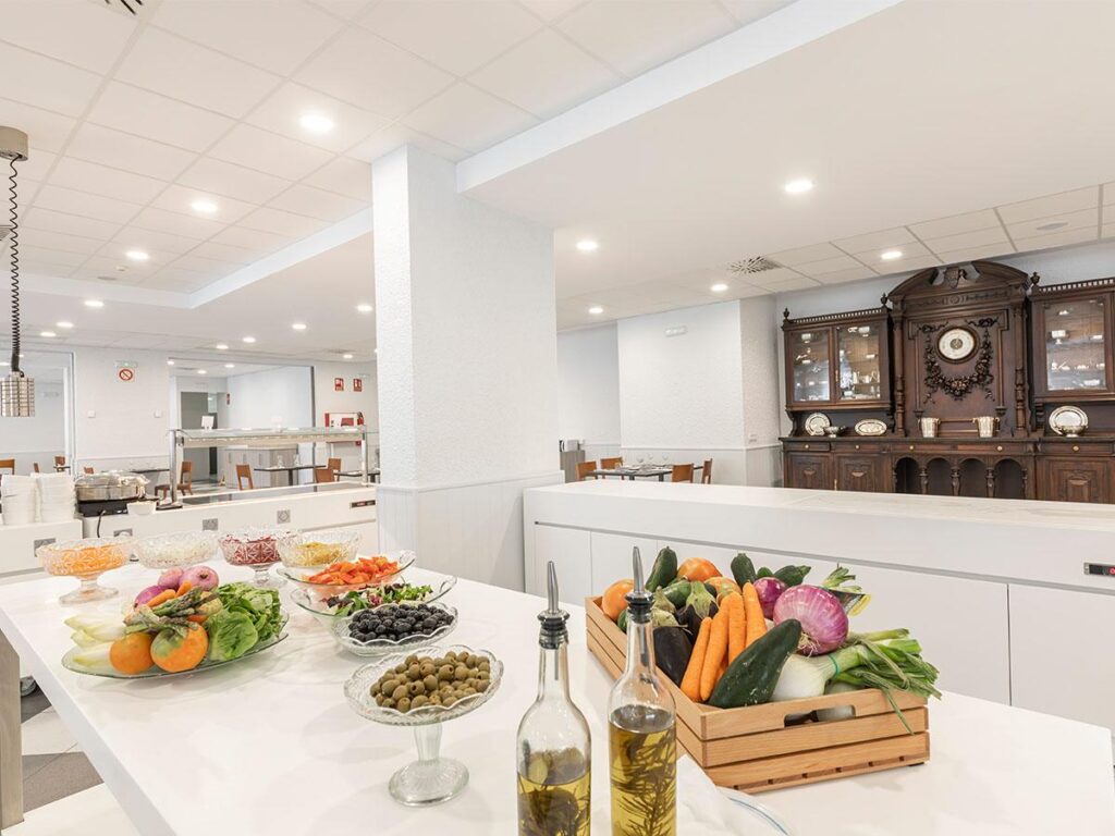 imagen del restaurante con una mesa en primer plano con diferentes tipo de alimentos de ensalada