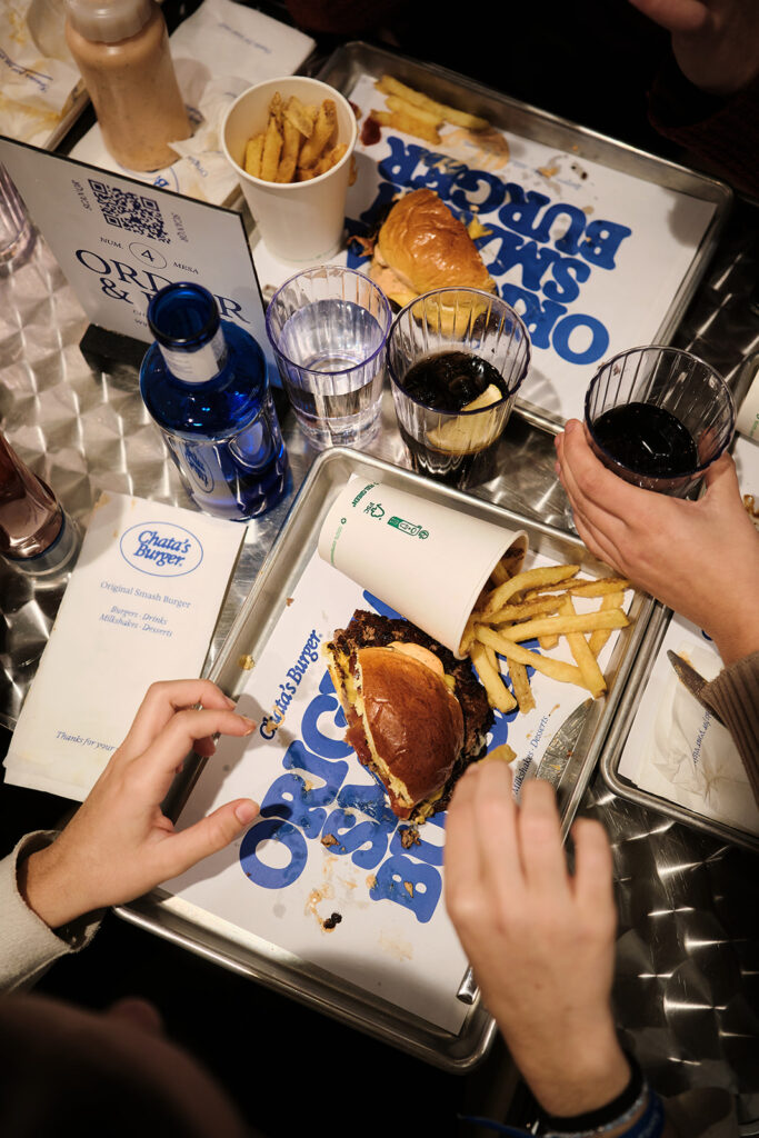 mesa del establecimiento se ve hamburguesa y bebidas