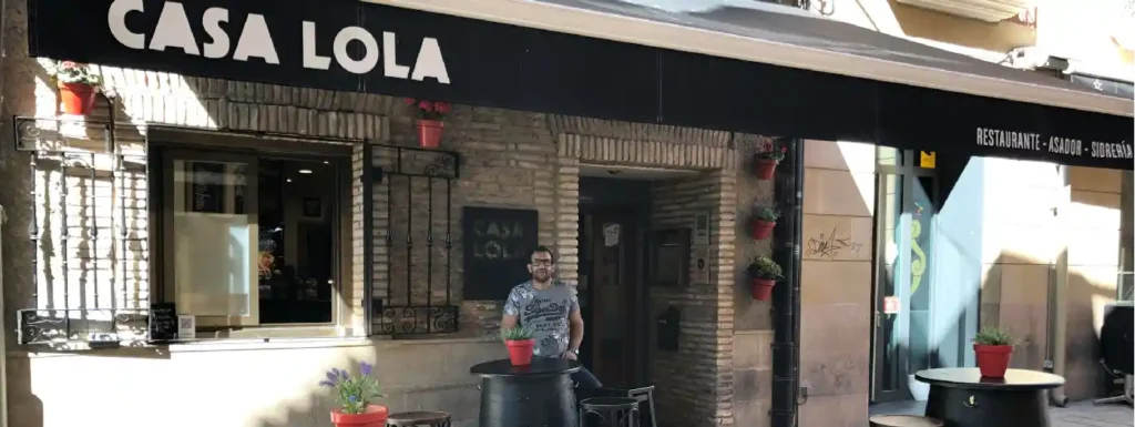 fachada de piedra del restaurante, junto con unas sillas.