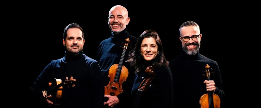 Los cuatro mirando al frente con los instrumentos, Posicionados en círculo.