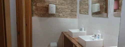 Aseo compatido, varias pilas elevadas y puertas de acceso a los aseos