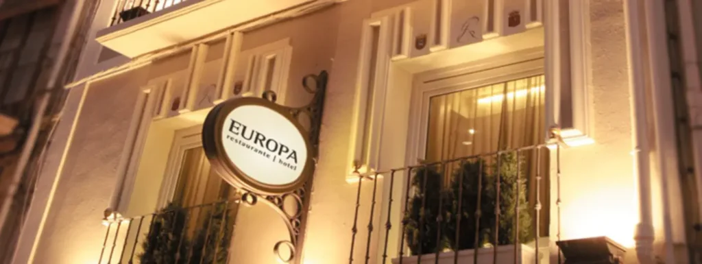 Fachada iluminada del Hotel Europa de Pamplona, con el cartel del nombre de este