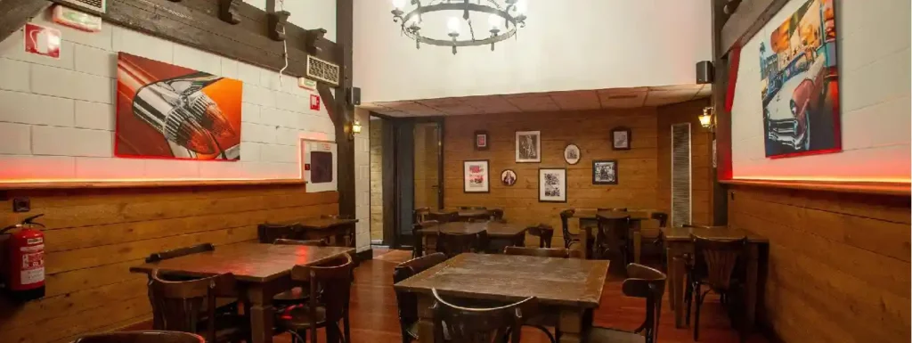 interior del restaurante, mesas con sillas y decoración rockera.
