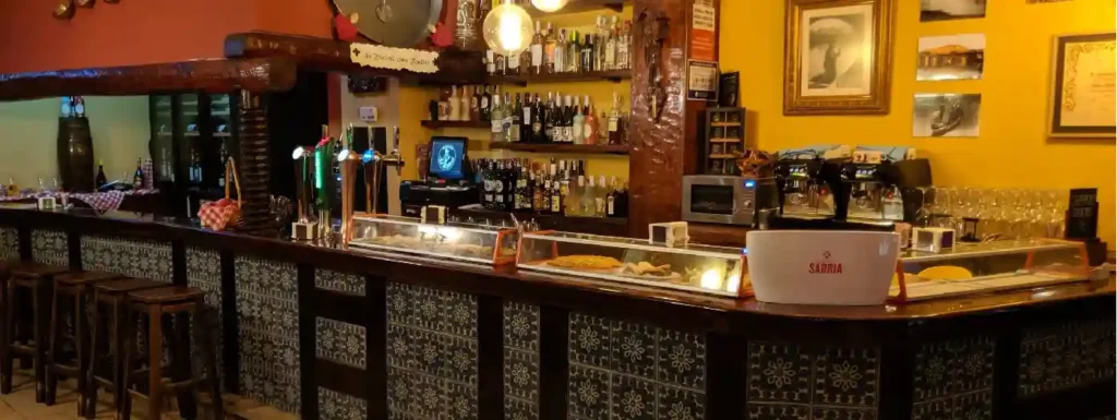 Barra del bar con pintxos y cervezas.