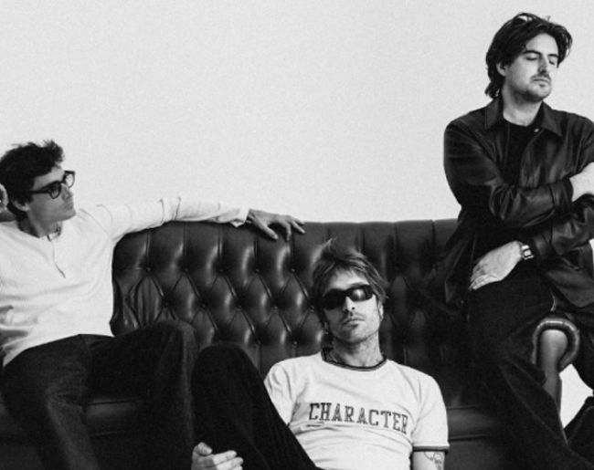 Integrantes Grupo Marlon sentados en un sofa