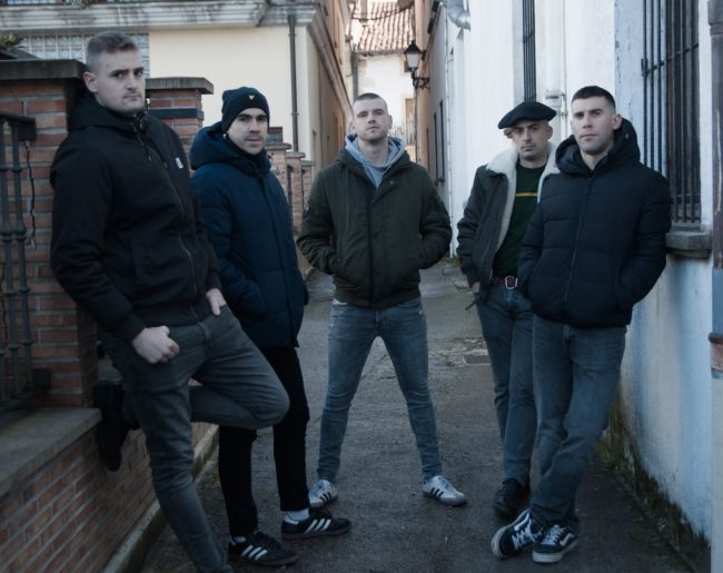 Los integrantes del grupo Nafarroa 1512 poisan en pie en el cartel del evento