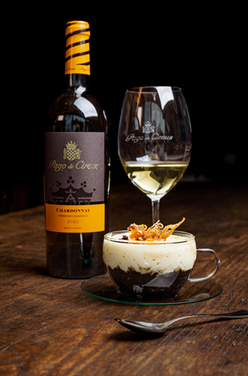 Bodegón con botella y copa de pago de cirsus y un postre