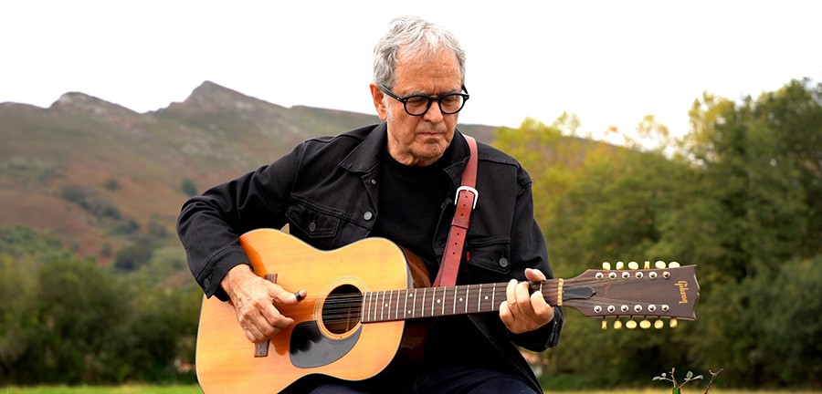 Ruper Ordorika tocando la guitarra en el campo
