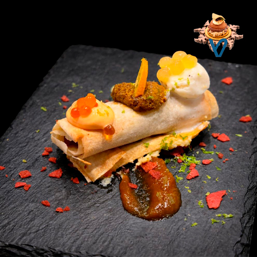 Rollito de banitsa relleno de carnita de panceta ibérica confitada con soja, mostaza y miel, sobre una mousse de piparra de Ibarra. Tiene una salsita suave de rocoto, un punto de pesto rojo con alga nori de Galicia «Bio» con kumquot y un toque fresco de albahaca y caviar de yuzu
