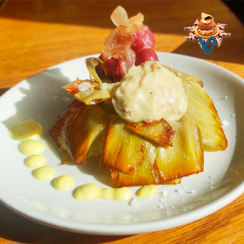 Flor de alcachofa a la plancha rellena de cremoso de foie y crujiente de ibérico.