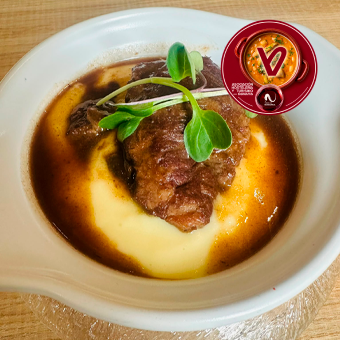 Carrillero de cerdo guisada, parmentier de patata y jugo reducido de su asado.