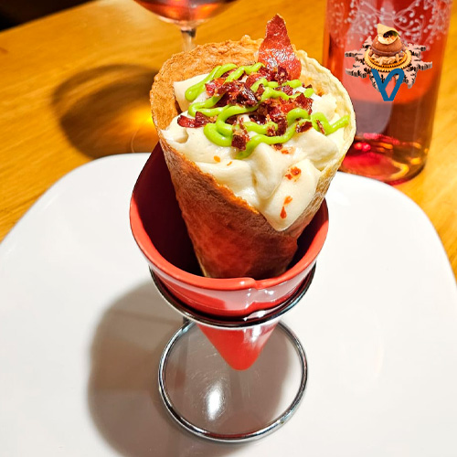 Cucurucho de verdura relleno de mousse de menestra de verduras con tropezones de alcachofas cardo zanahoria guisantes arena de jamón y sirope de verduras.