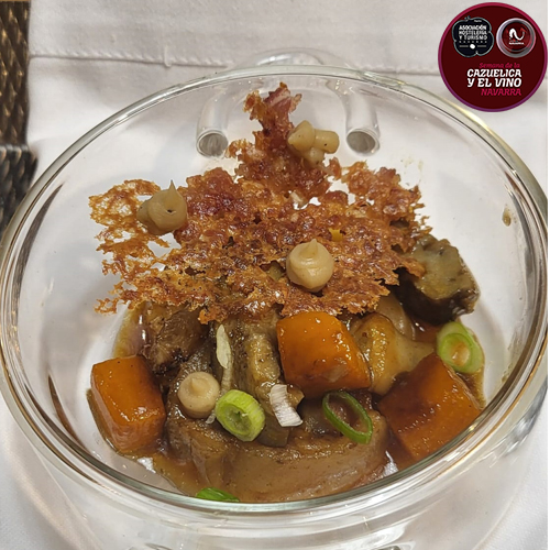 Caldo oscuro de cerdo con calabaza, hongos y manitas estofadas, coronado con una teja crujiente de oreja que hace a su vez de pan.