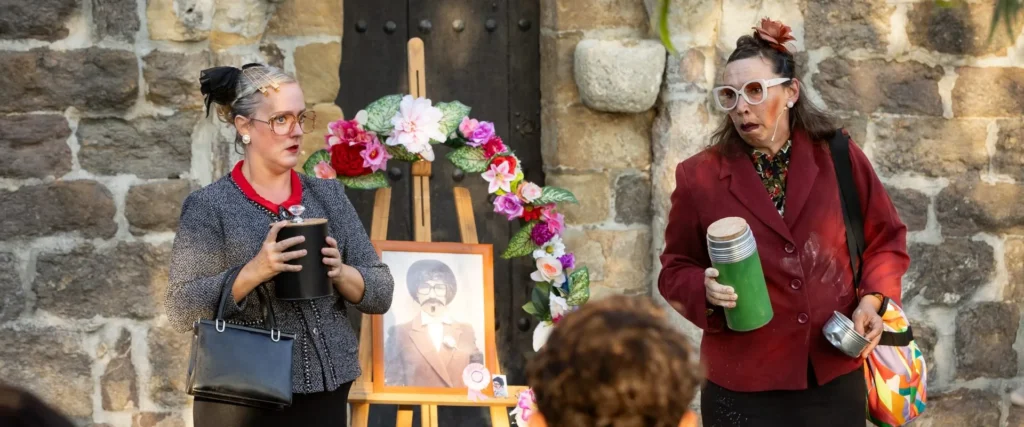 Milagros y Valentina han estado juntas toda su vida y ahora también están juntas en su viudedad. Sus maridos han querido que su despedida fuera este día. escena durante su actuación