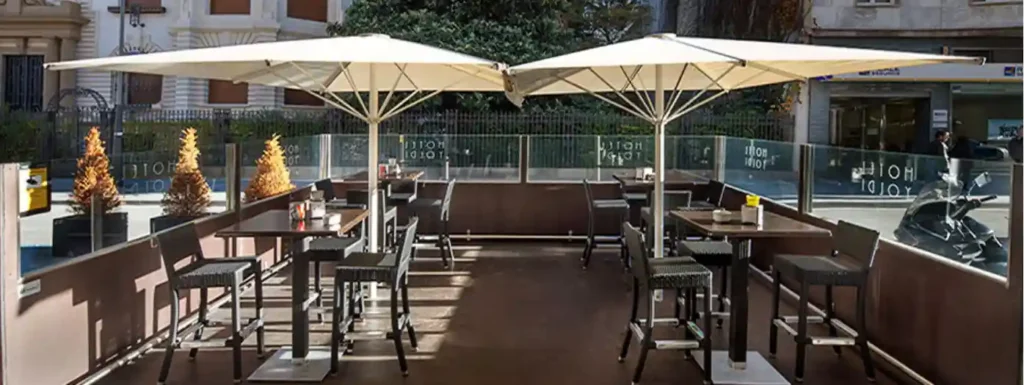 terraza del restaurante yoldi con dos sobrillas y mesas de taburetes.