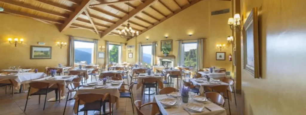 Comedor luminoso, con paredes amarillas y mesas montadas para dar el servicio