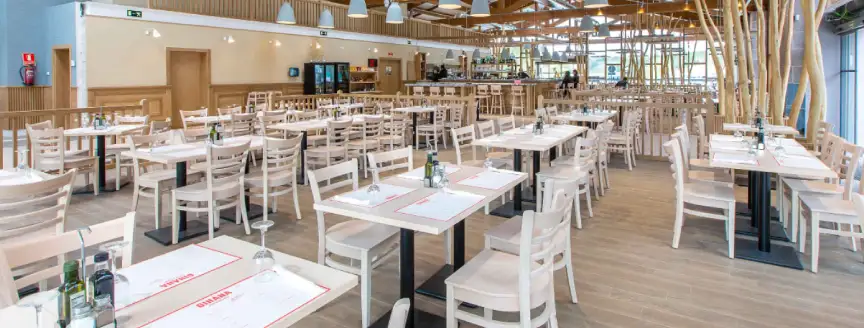 amplio comedor con muchas mesas blancas montadas para el servicio