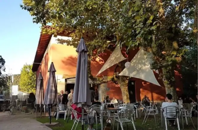 Terraza con sombrillas, delante del edificio en el que se encuentra el bar