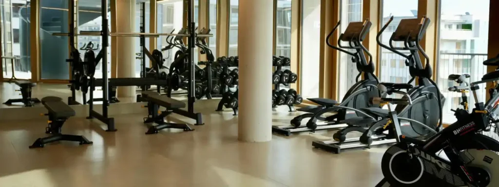 gimnasio en el que se ve equipamiento de peso y cardio