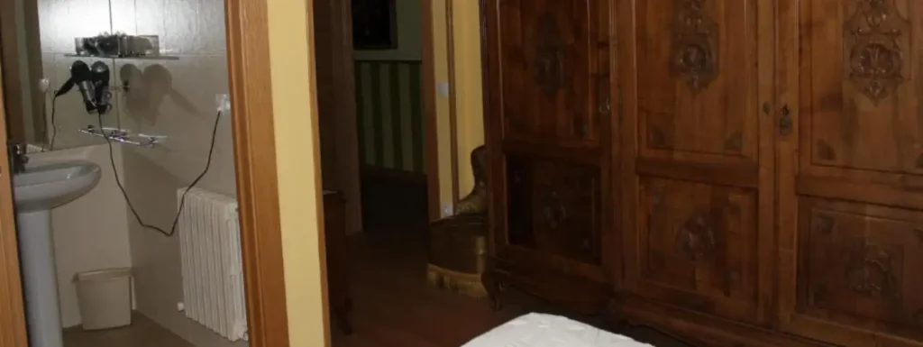 armario de madera maciza, acceso al servicio y a la salida de la habitación