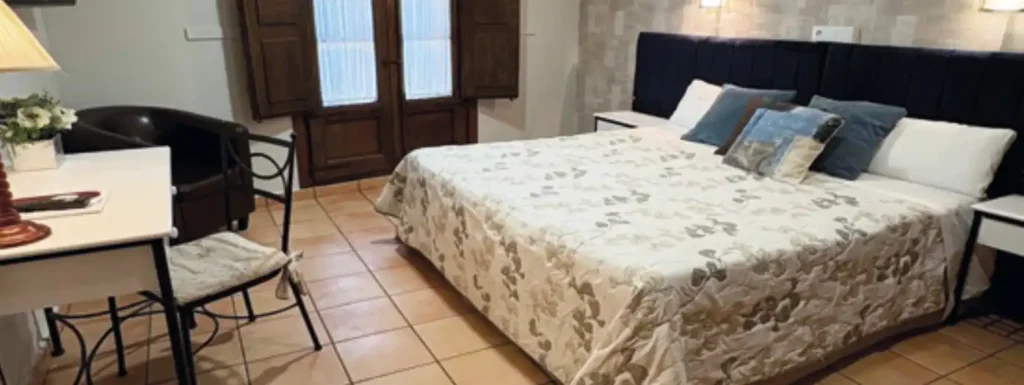 habitación doble, con ventanal de madera y escritorio