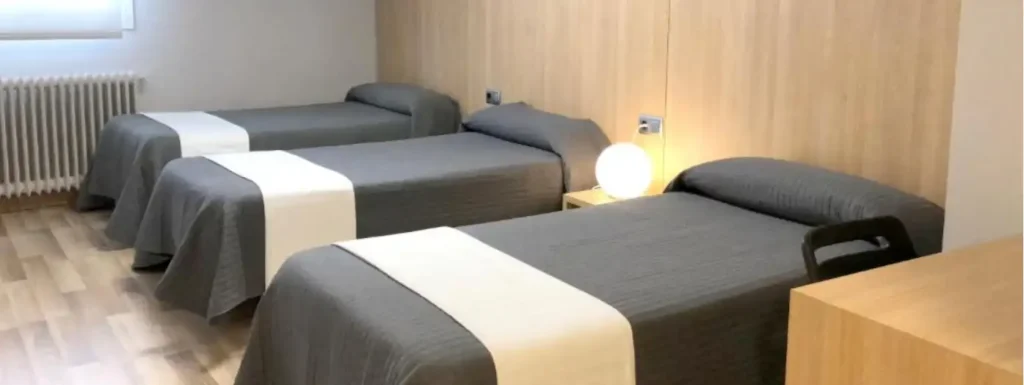 habitación triple con camas individuales. Cabecero de madera