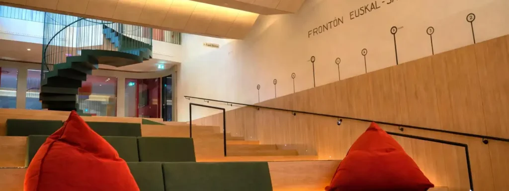 espacio de estilo anfiteatro, con butacas verdes cojines rojos