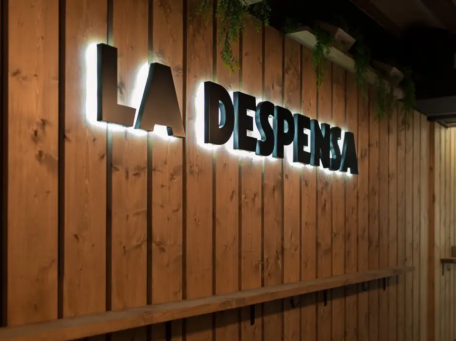 pared de madera laminada, estilo caja, con logotipo con relieve iluminado desde atrás