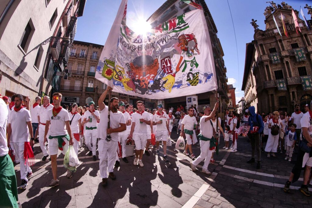 Una peña de Pamplona recorre sus calles portando la pancarta y con su música
