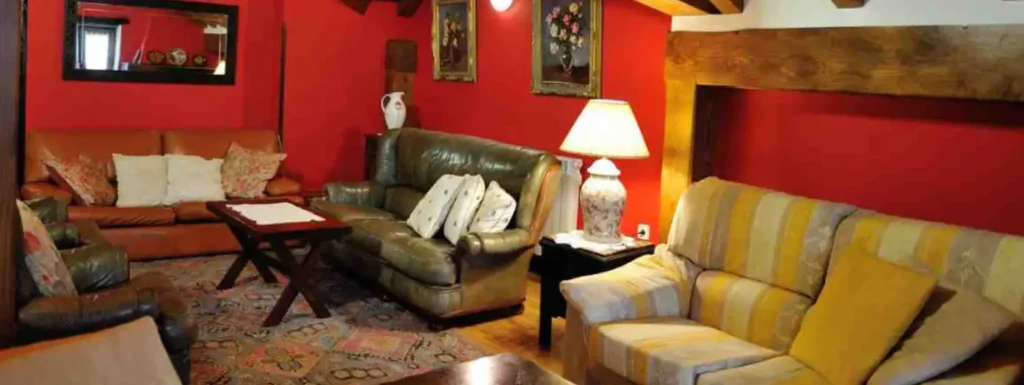 amplio salon con diferentes sofas, mesa auxiliar en el centro con una lampara