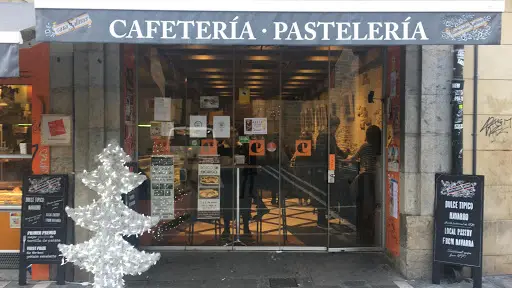 Fachada y entrada con puerta de cristal de la cafeteria, con toldo en el que aparece el nombre