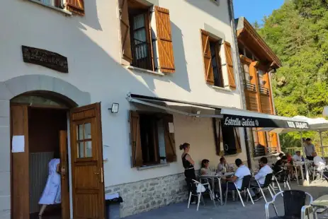 Casa del pirineo Navarro donde se encuentra el alojamiento, con una gran terraza repleta de gente