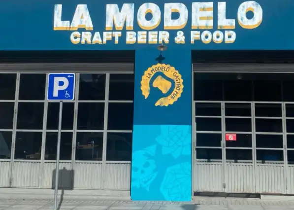 Fachada azul llamativa, nombre en grande en laparte superior, hace referencia a un garaje antiguo
