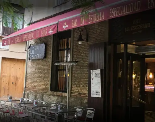fachada de piedra, con terraza en el exterior y porton de madera