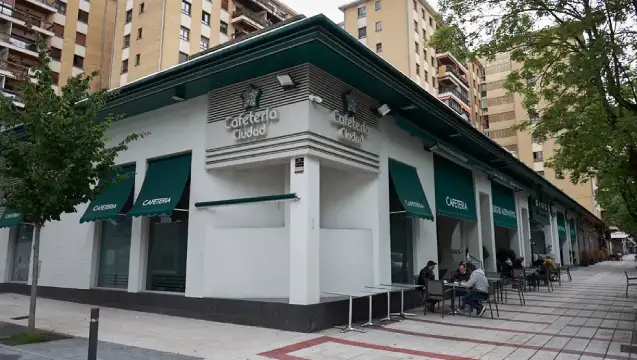 Fachada blanca con detalles en verde, de la cafeteria del bingo