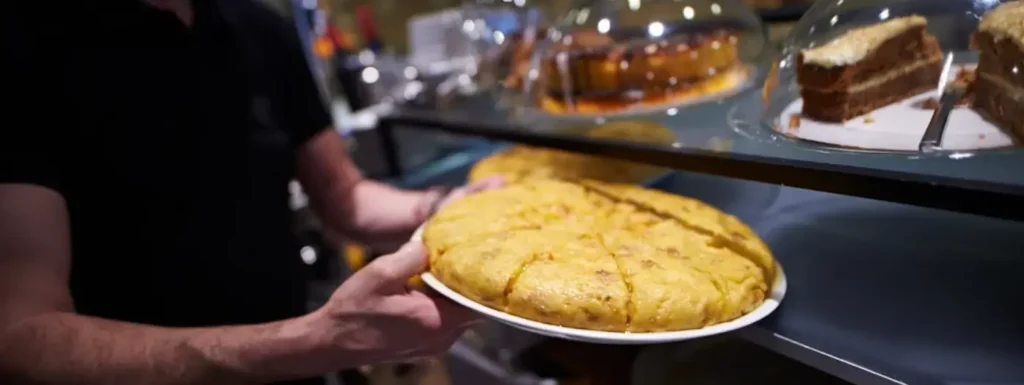 Tortilla de patata sostenida por un camarero de Elizalde