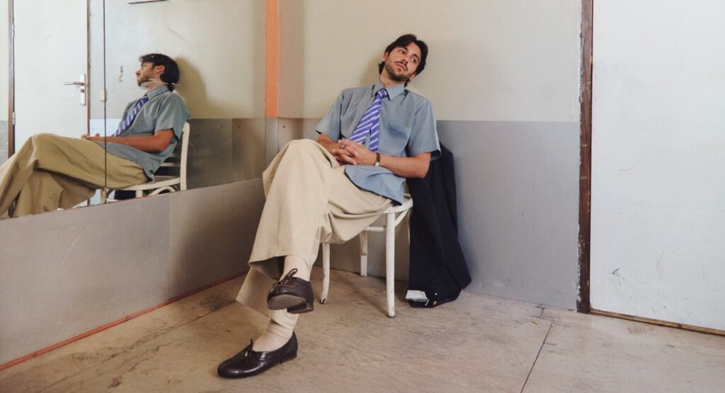 Yerai cortes, guitarrista flamenco, sentado en una silla, puede ser la portada de algún disco.