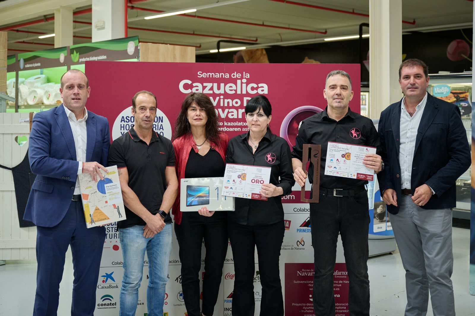 Entrega del Premio Oro de la 25ª Semana de la Cazuelica y el Vino D.O. Navarra, con el equipo ganador mostrando el diploma, la escultura y los obsequios recibidos.
